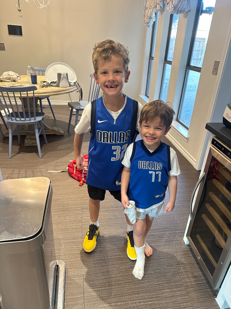 Two boys in matching Dallas jerseys smiling in the kitchen